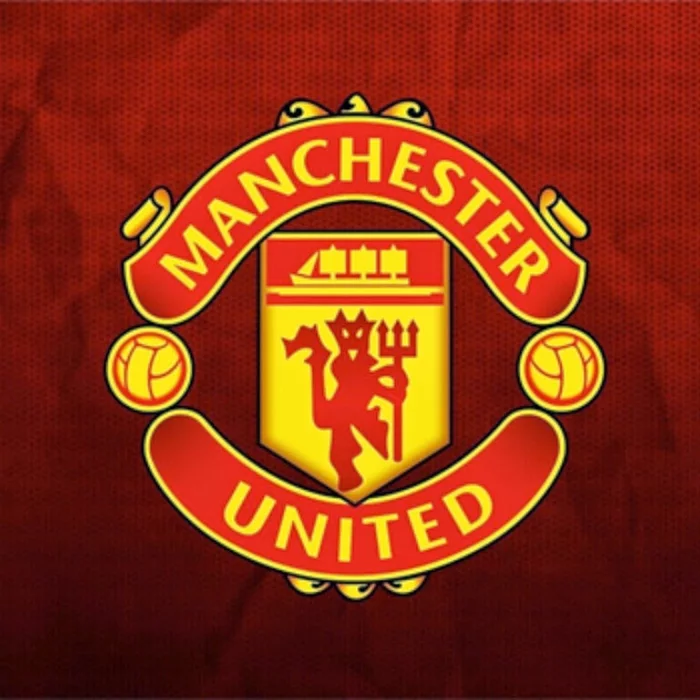 Logo MU truyền thống trên nền đỏ.