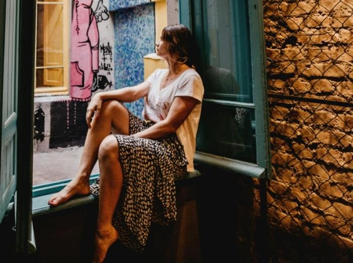 cô gái ngồi bên cửa sổ trên tầng cao