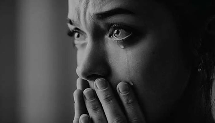 hình cô gái khóc che mặt trong bóng tối