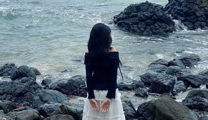 hình cô gái quay lưng đơn giản trên bãi đá