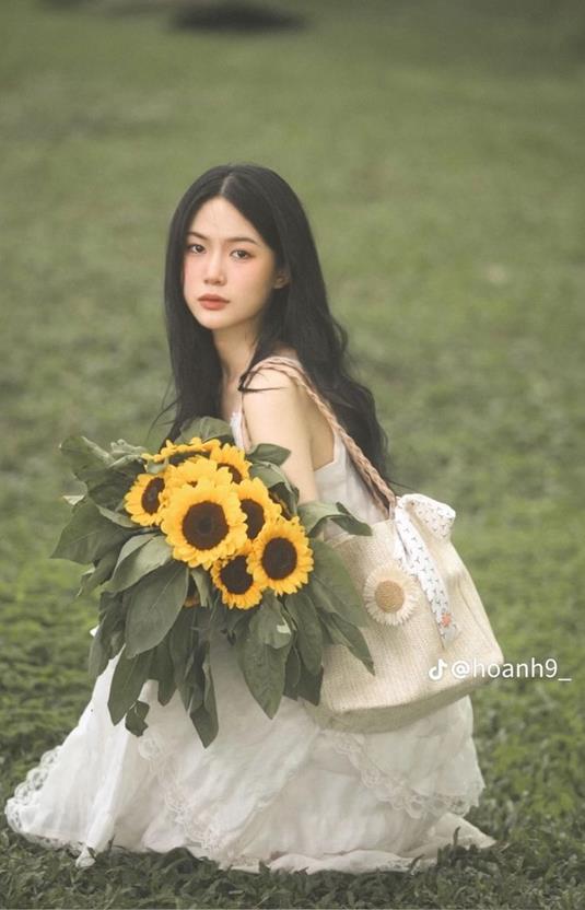 cô gái cầm hoa hướng dương xinh đẹp
