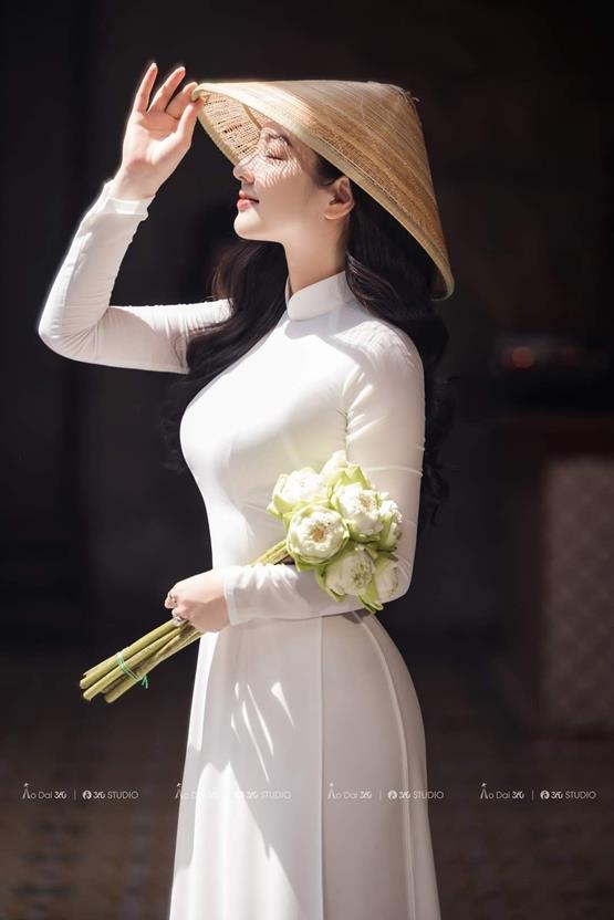 gái xinh cầm hoa sen trắng đón nắng mai