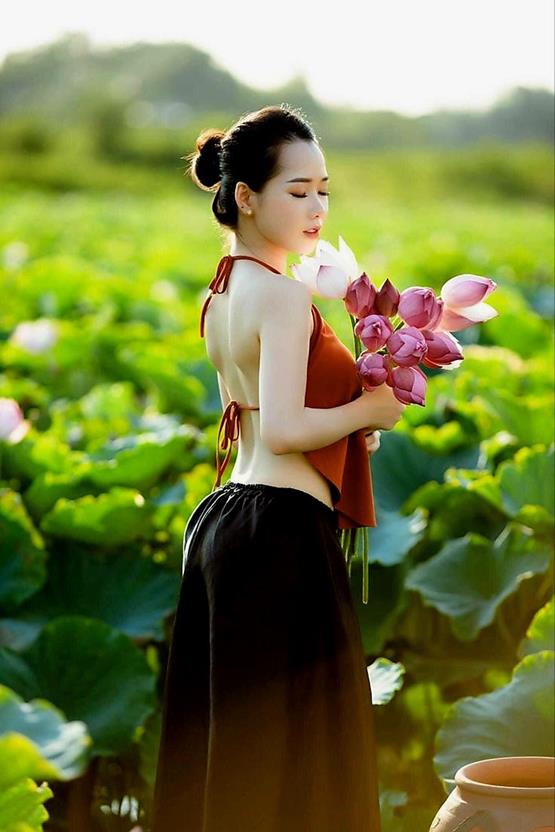 cô gái cầm hoa sen hồng mặc áo yếm