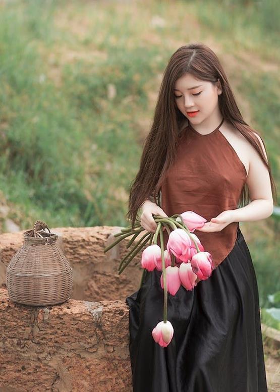 cô gái cầm hoa sen hồng khung cảnh bình yên