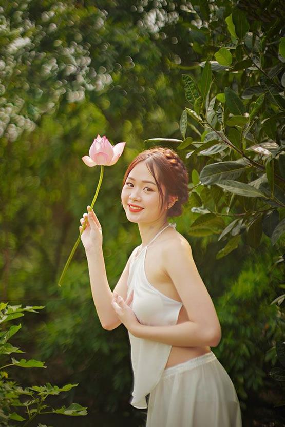 cô gái cầm hoa sen hồng đáng yêu