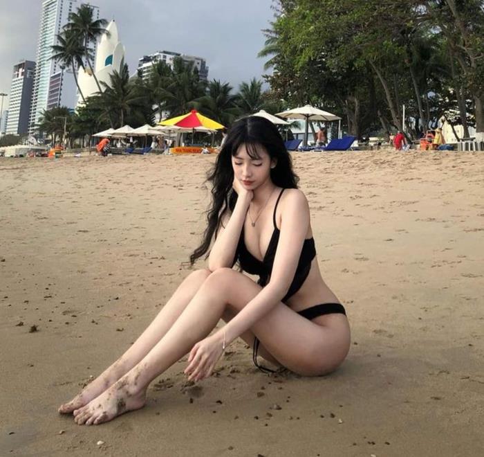 hình gái mặc bikini đen ngồi trên bãi cát