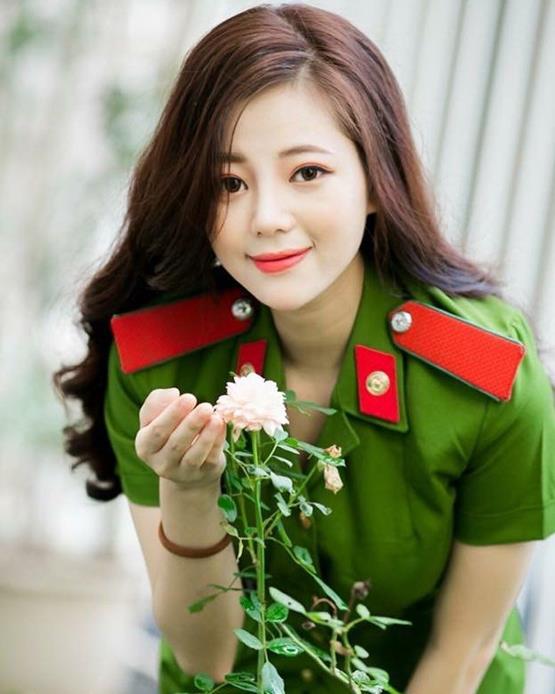 Hình nữ công an tóc dài chụp ảnh cùng hoa