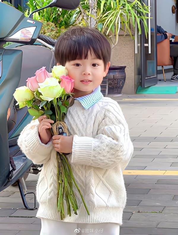 Hình bé trai đáng yêu cầm hoa