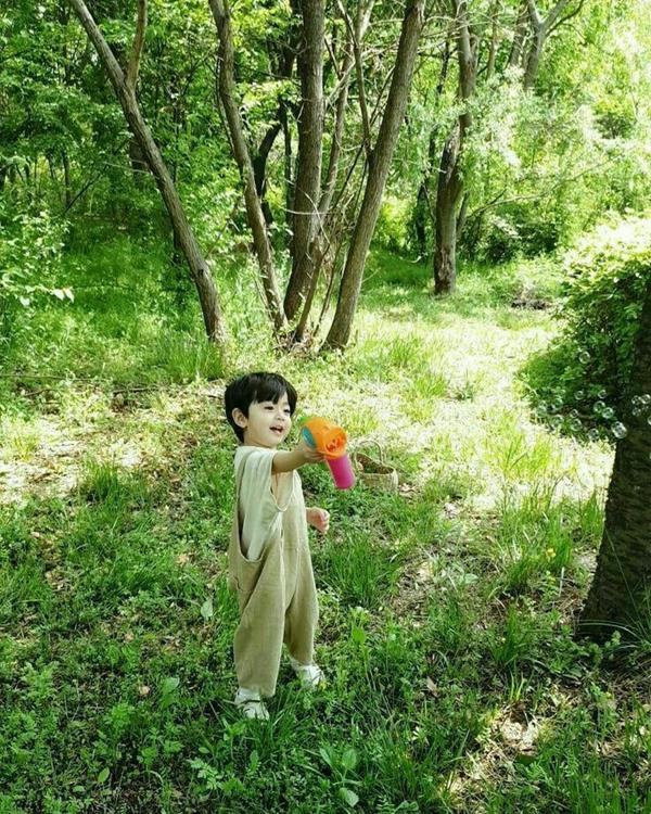 Ảnh em bé cute nam trong vườn cây