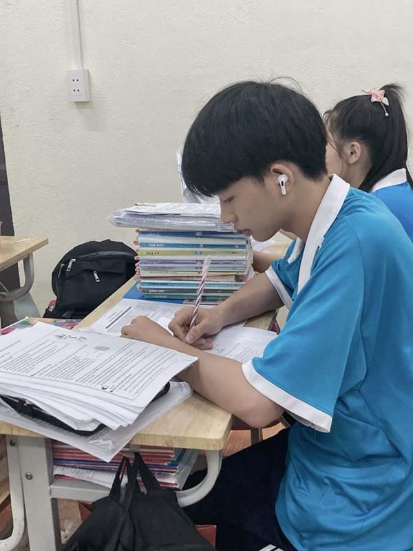 Hình sinh viên nam viết bài trên lớp