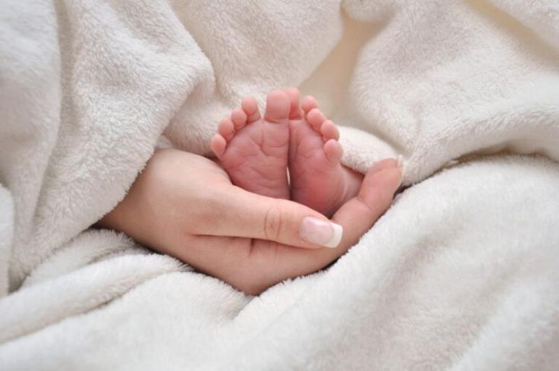 Hình ảnh bàn chân em bé nhỏ nhắn mẹ nâng niu