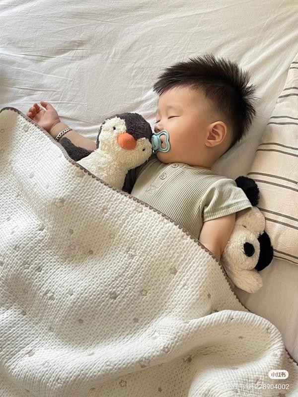 Hình bé ngủ ôm chim cánh cụt bông 