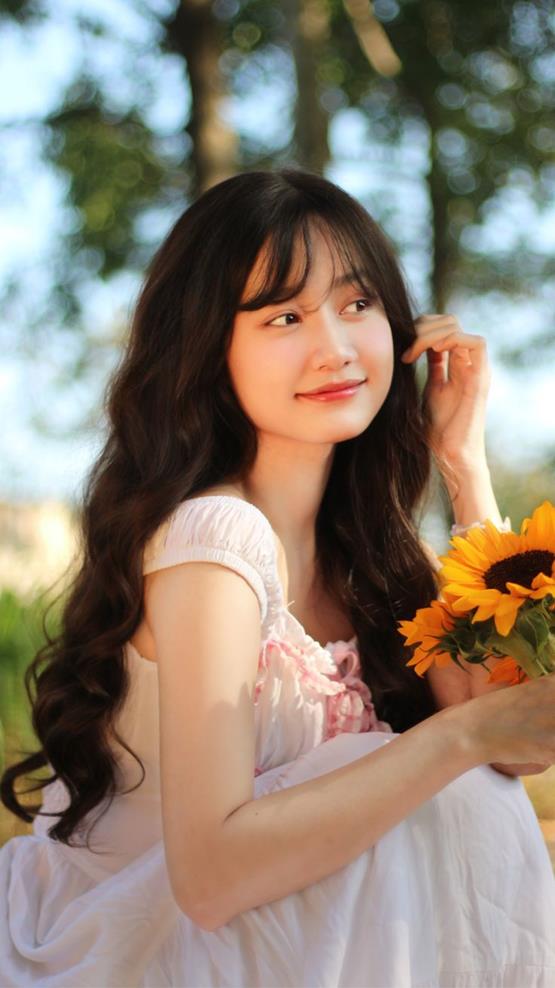 Ảnh cô gái cầm hoa hướng dương cười mỉm