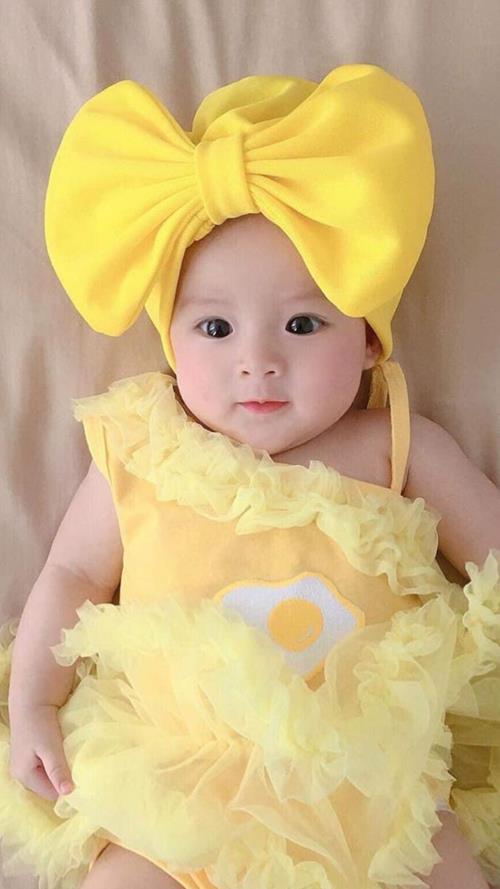 Ảnh nền em bé gái sơ sinh đeo nơ vàng cute