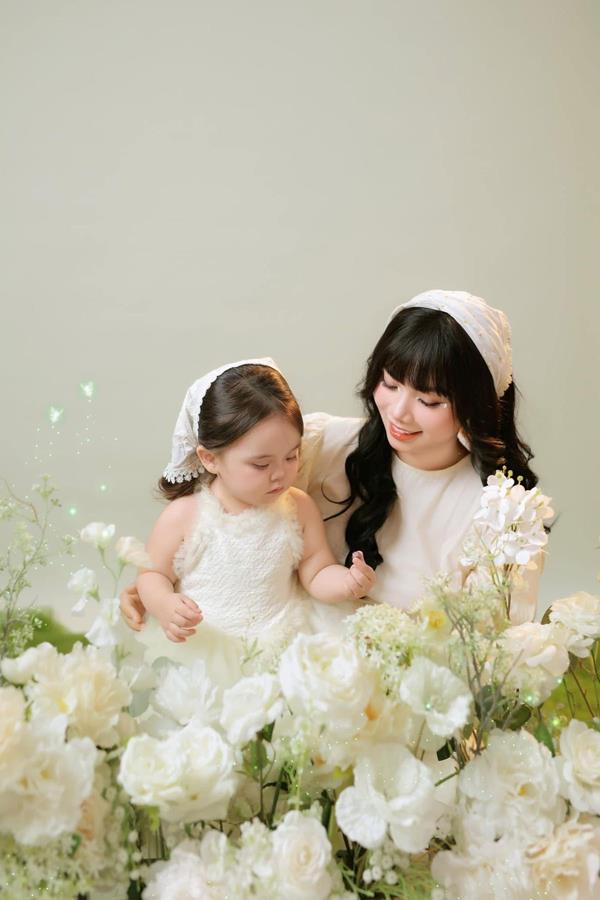 Hình mẹ và bé gái chơi đùa cùng hoa