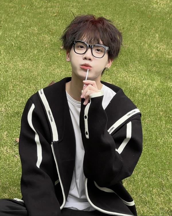 Trai đeo kính cute ngồi bãi cỏ